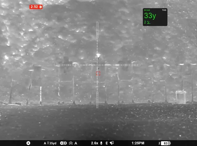 White-hot view at 2.6x, rangefinder showing 33 yards on the target line