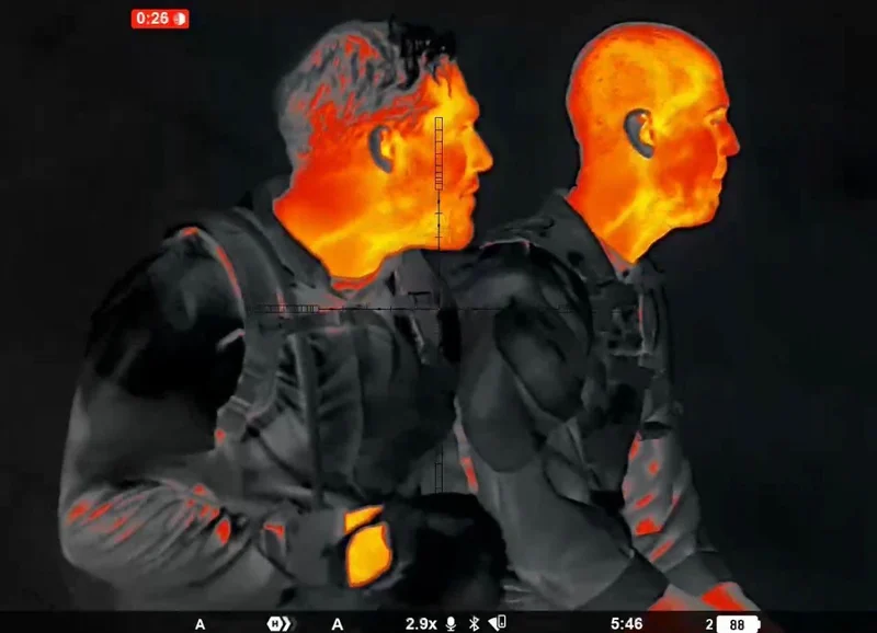 Red and orange view at 2.9x: two people with heat detail on faces, ears, and gear