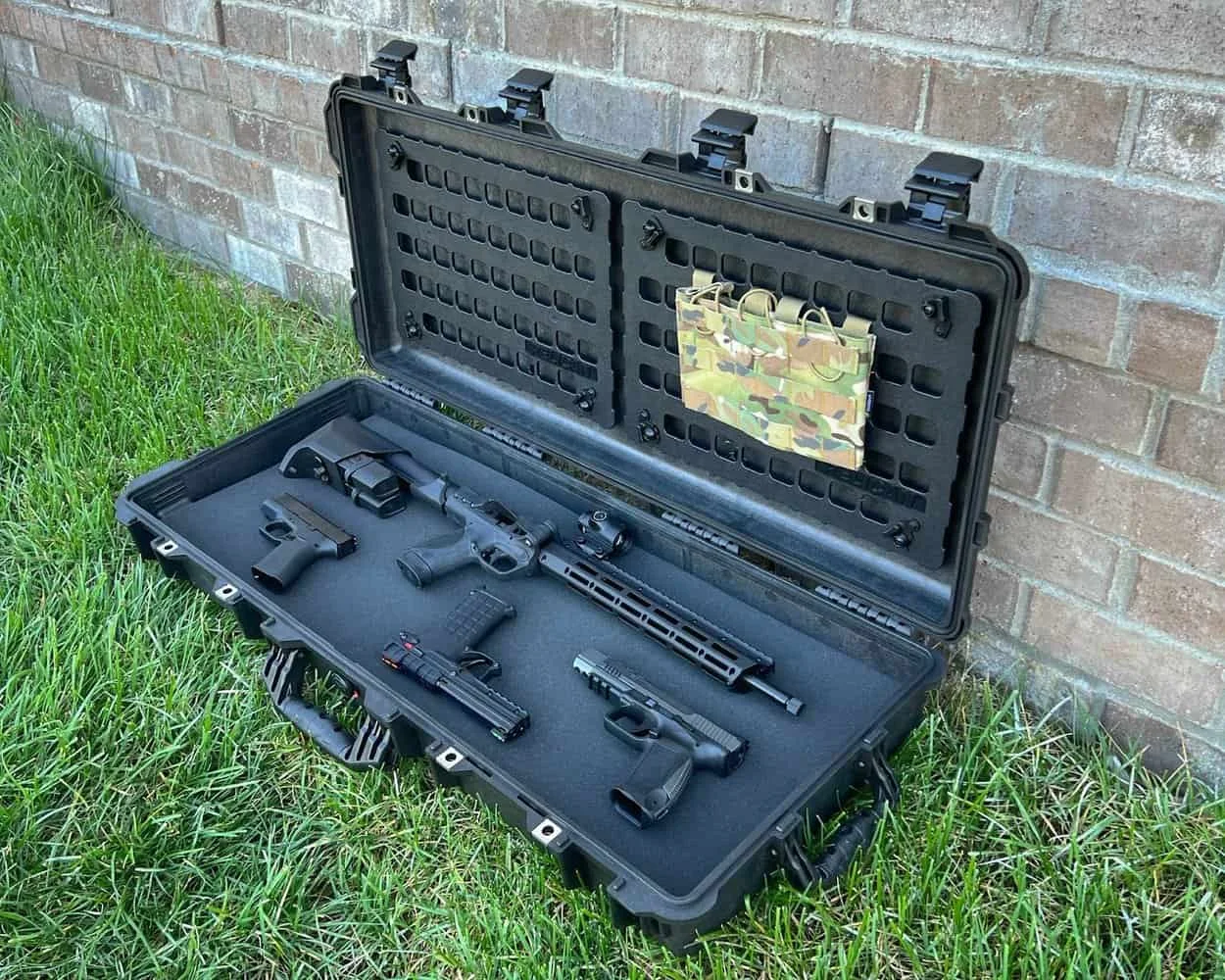 pelican 1700 series case with rifle and three handguns inside sitting on grass
