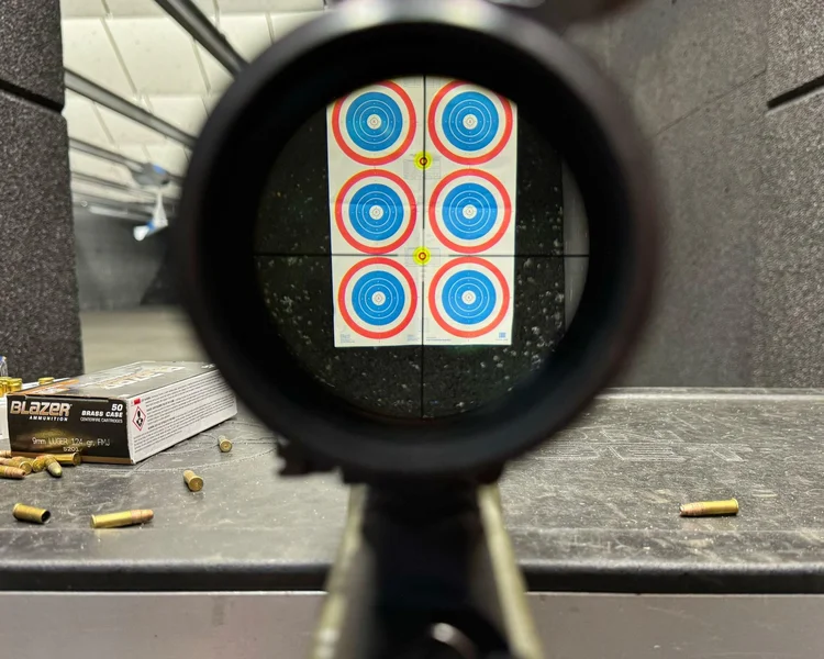 Aiming the Model 2020 Rimfire rifle at a distant target, emphasizing the shooter’s focus and precision during testing