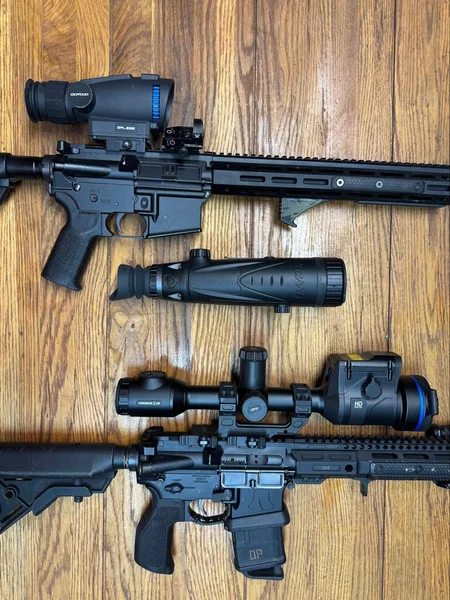 Goyojo GRL335 on one rifle and the Pulsar Thermion 2 LRF XL60 on another, laid out on a wood floor