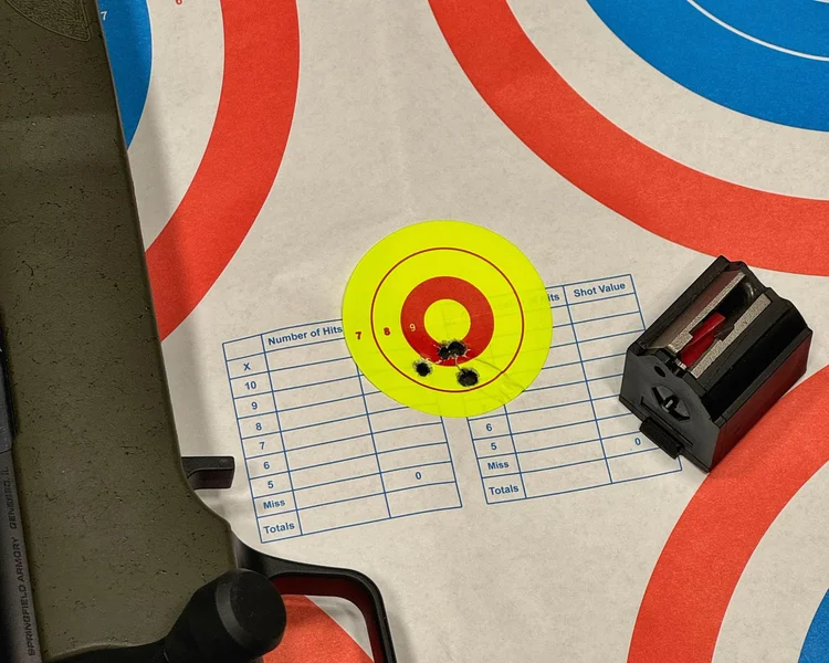Paper target with shot groupings from the Model 2020 Rimfire’s first magazine at 20 yards, showcasing accuracy in close-range testing