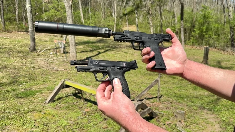 Comparing two Smith & Wesson M&P22 rimfire pistols in an outdoor woods environment